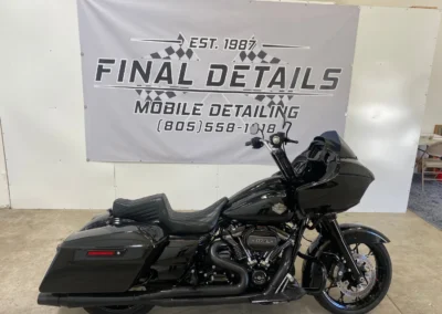 A sleek black Harley-Davidson motorcycle parked indoors at Final Details Mobile Detailing shop.