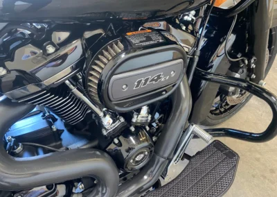 Close-up of a Harley-Davidson 114ci engine, showcasing the air filter and black chrome detailing.